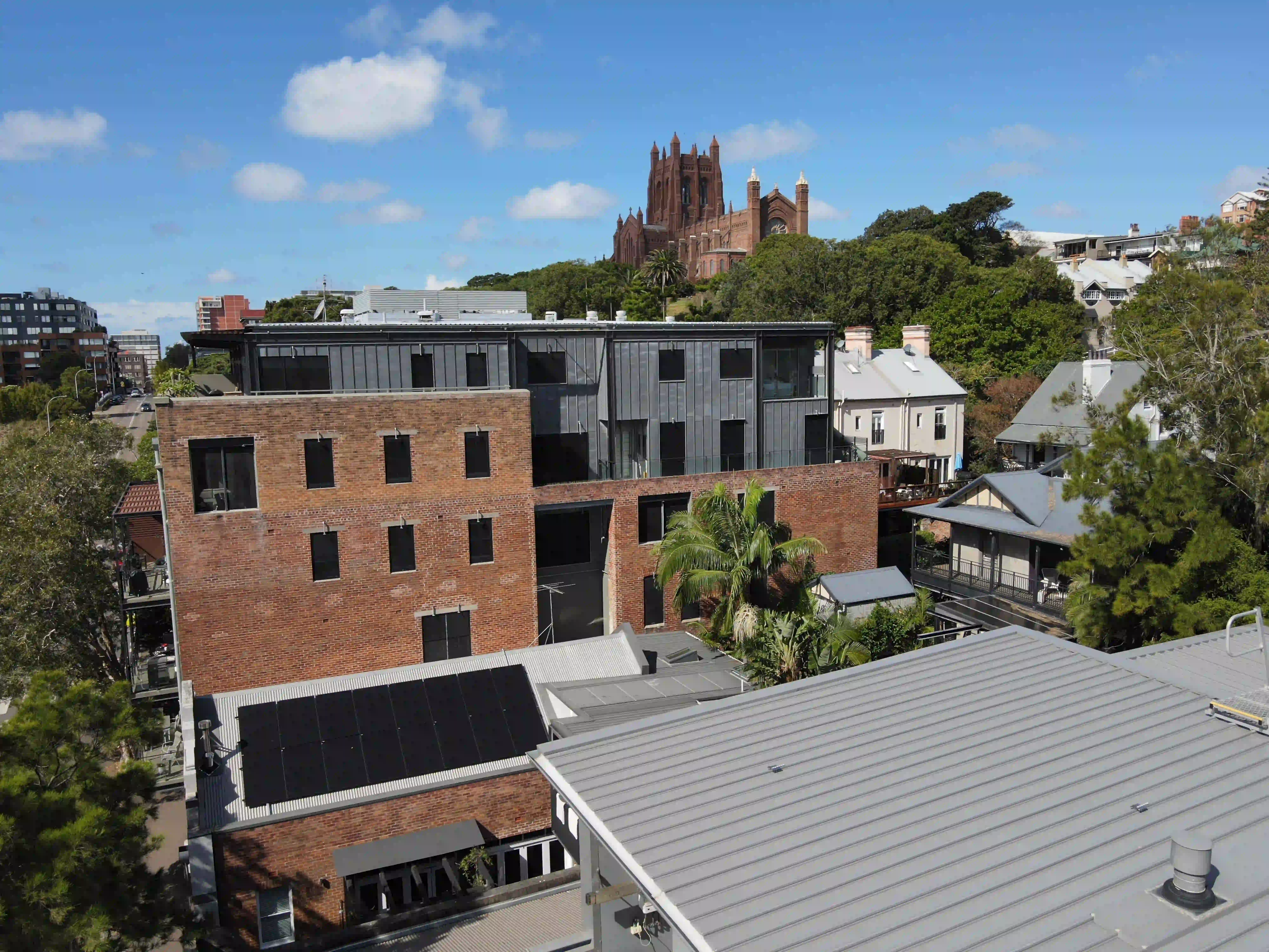 Drone view over Newcastle city with a Newy Solar Co rooftop solar installation and Christ Church Cathedral behind