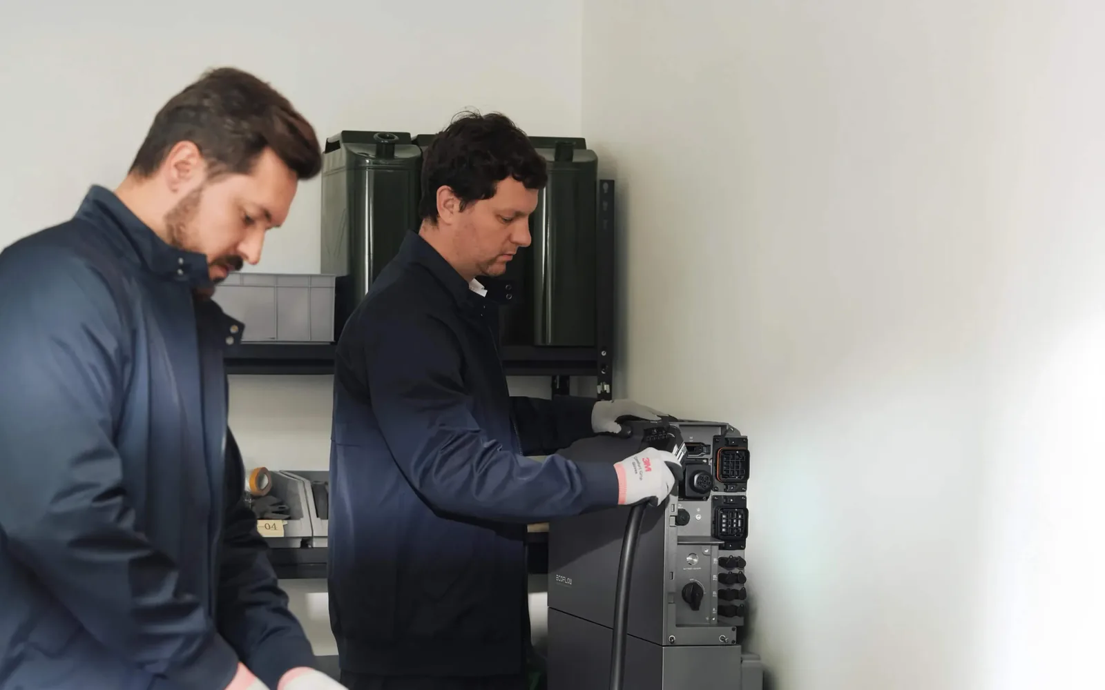 Technicians connecting cabling to an EcoFlow OCEAN 2 hybrid inverter during commissioning