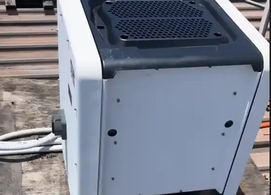 A rooftop SMA inverter showing degradation mounted on a scrap piece of plywood